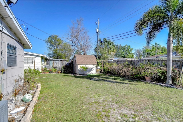 view of yard with a fenced backyard, an outdoor structure, and a shed