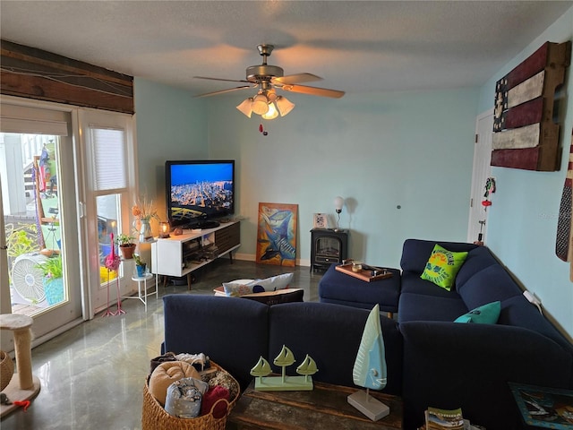 living room with a wood stove and a ceiling fan