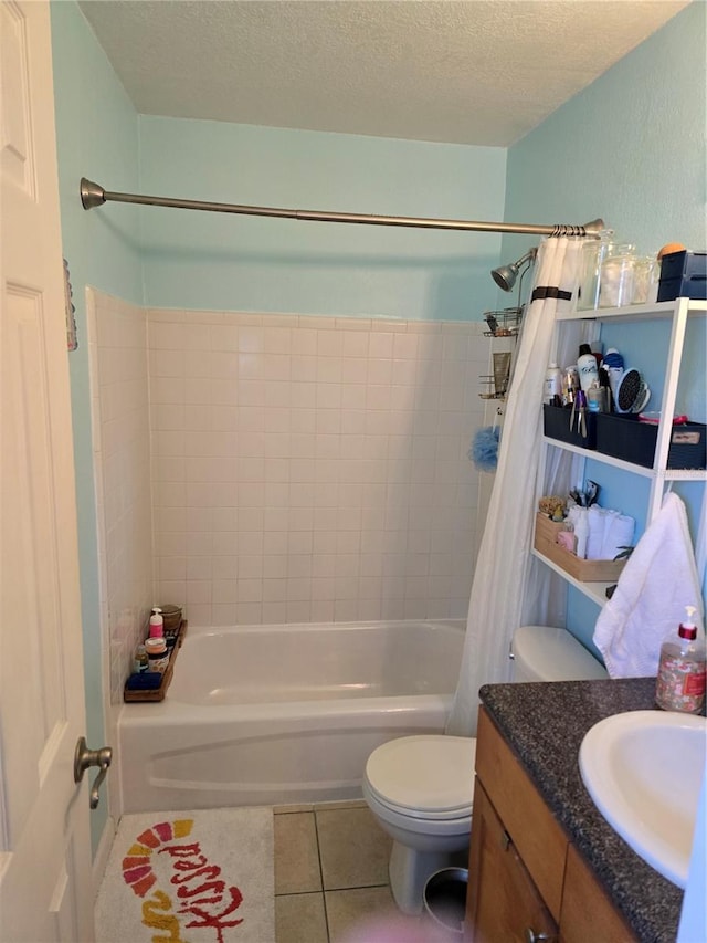 full bathroom featuring toilet, tile patterned floors, shower / bath combo with shower curtain, a textured ceiling, and vanity