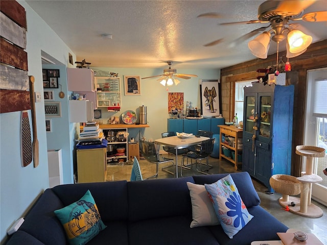 living room featuring a ceiling fan, concrete floors, and a textured ceiling