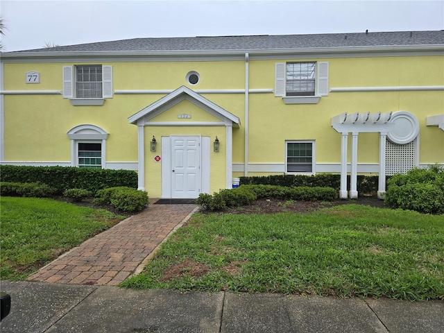 view of front of home with a front lawn and stucco siding