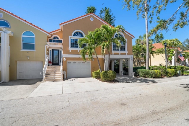 view of front of home with driveway, an attached garage, and stucco siding