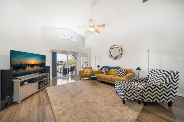 living area with high vaulted ceiling, wood finished floors, and a ceiling fan