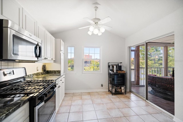 kitchen featuring appliances with stainless steel finishes, white cabinets, vaulted ceiling, and light tile patterned floors