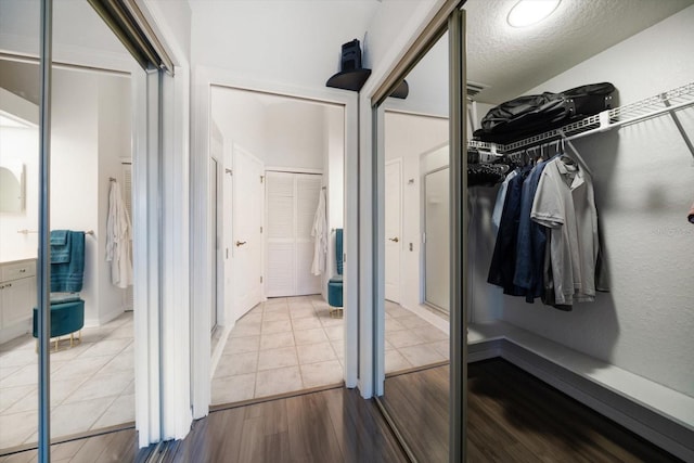 bathroom featuring a spacious closet and wood finished floors