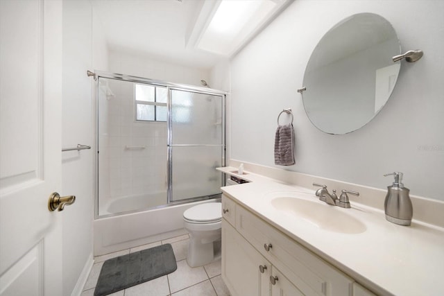 bathroom with tile patterned flooring, enclosed tub / shower combo, vanity, and toilet