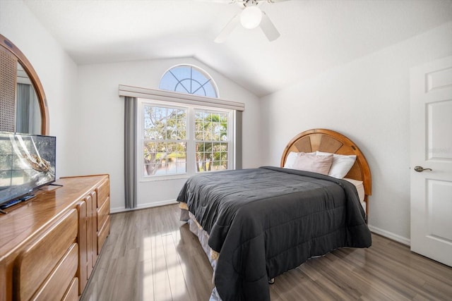 bedroom featuring lofted ceiling, baseboards, ceiling fan, and light wood finished floors