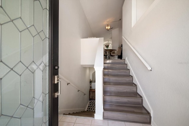 stairway featuring tile patterned flooring and baseboards