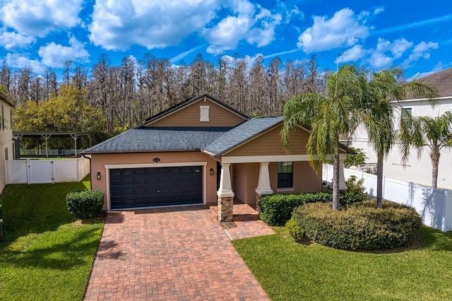 view of front of property with a gate, fence, a front lawn, and decorative driveway