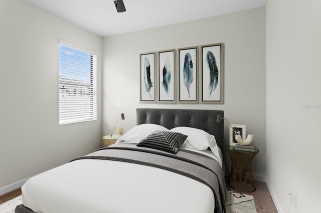 bedroom with a ceiling fan, carpet flooring, and baseboards