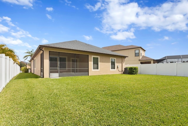 rear view of property with a sunroom, a fenced backyard, a lawn, and central air condition unit