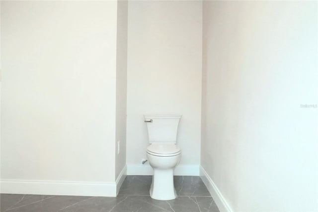 bathroom with toilet and baseboards