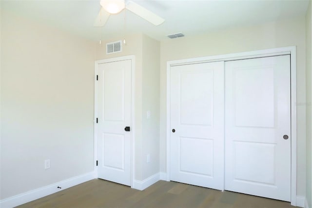 unfurnished bedroom featuring visible vents, dark wood finished floors, and baseboards