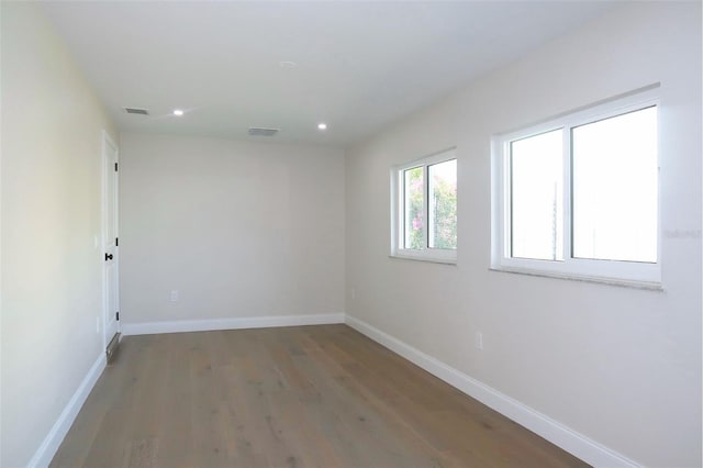 unfurnished room with baseboards, visible vents, wood finished floors, and recessed lighting