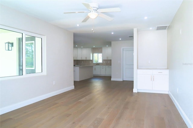 unfurnished living room featuring a ceiling fan, baseboards, visible vents, and light wood finished floors