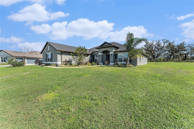 view of front of home with a garage, a front lawn, and stucco siding