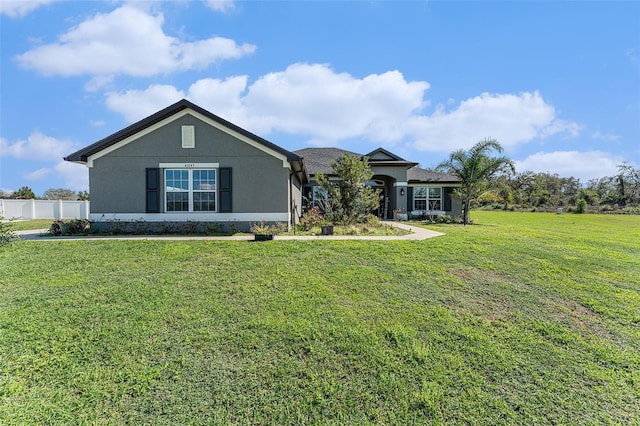 view of front of home featuring a front yard, fence, and stucco siding