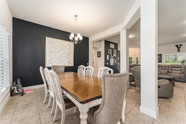 dining area featuring a chandelier, visible vents, baseboards, and light tile patterned floors