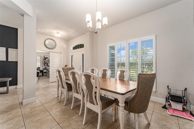 dining area featuring light tile patterned floors, baseboards, and a chandelier