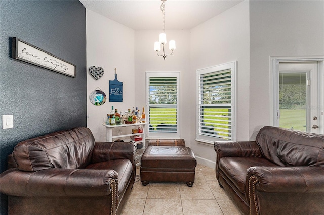 living area featuring light tile patterned floors, baseboards, and a notable chandelier