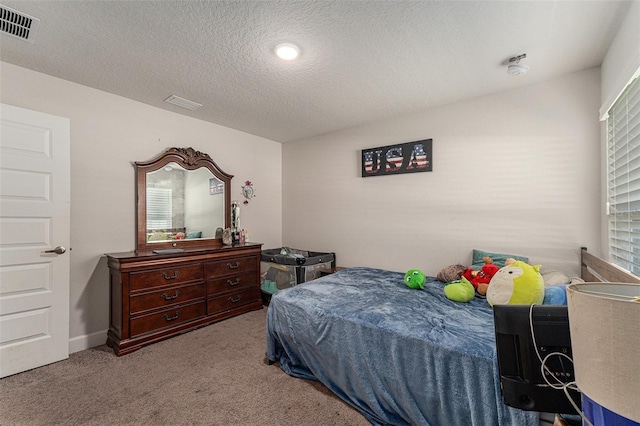 carpeted bedroom with a textured ceiling and visible vents