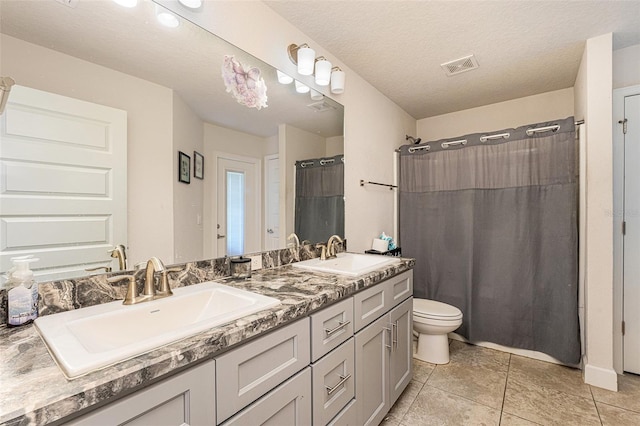 full bathroom with visible vents, a sink, toilet, and double vanity