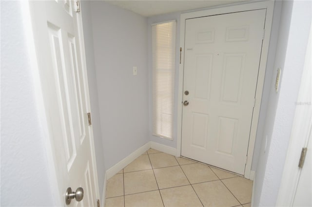 doorway to outside featuring light tile patterned floors and baseboards