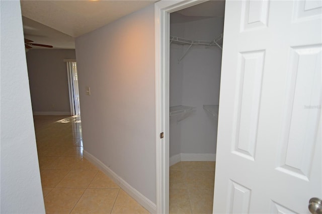 hallway featuring light tile patterned floors and baseboards