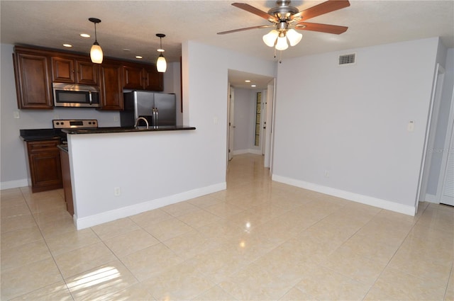 kitchen featuring a ceiling fan, baseboards, visible vents, stainless steel appliances, and dark countertops