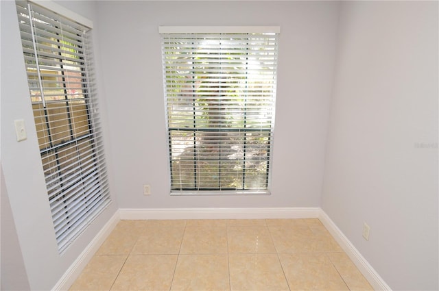 unfurnished room with a wealth of natural light and light tile patterned floors