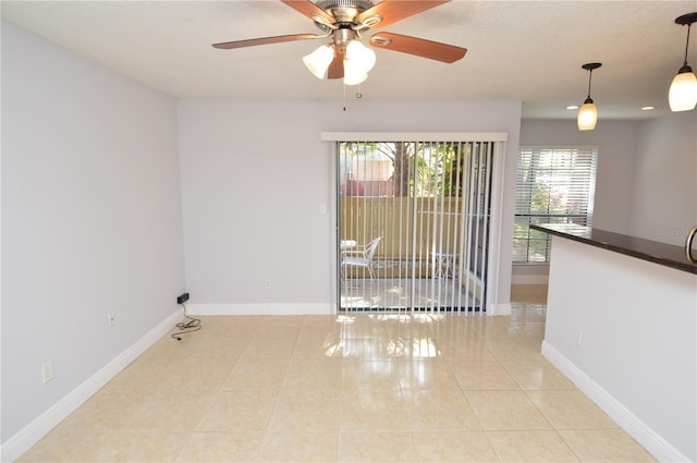 unfurnished room featuring light tile patterned floors, ceiling fan, and baseboards