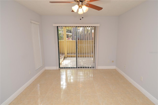 tiled spare room featuring baseboards and ceiling fan