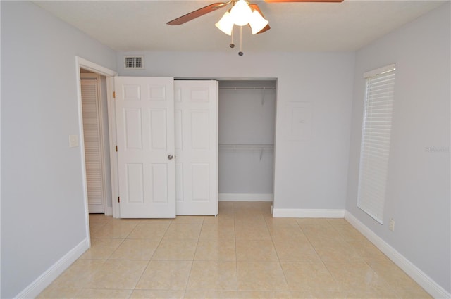 unfurnished bedroom with visible vents, ceiling fan, baseboards, light tile patterned floors, and a closet