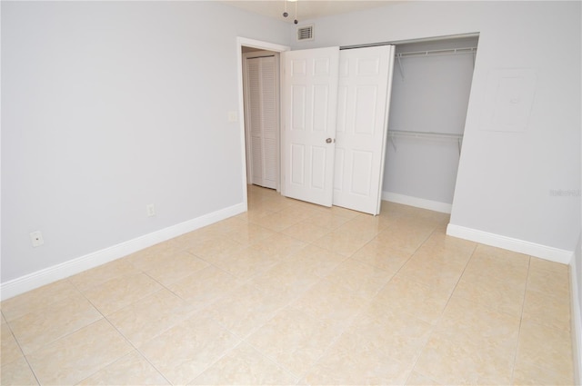 unfurnished bedroom with a closet, visible vents, baseboards, and light tile patterned floors