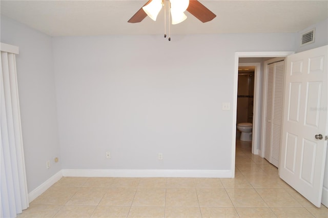 spare room with light tile patterned floors, visible vents, baseboards, and a ceiling fan