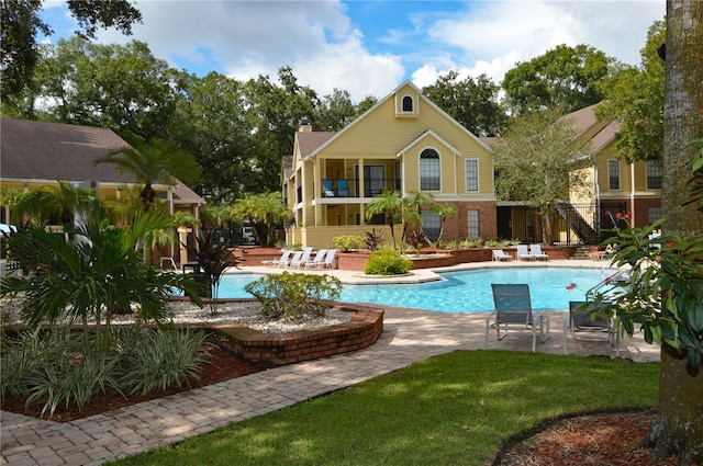 pool featuring a patio, fence, and a lawn