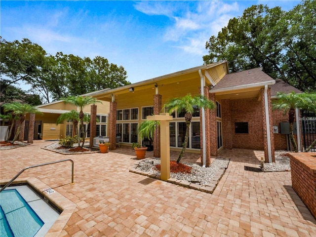rear view of house featuring a patio and brick siding