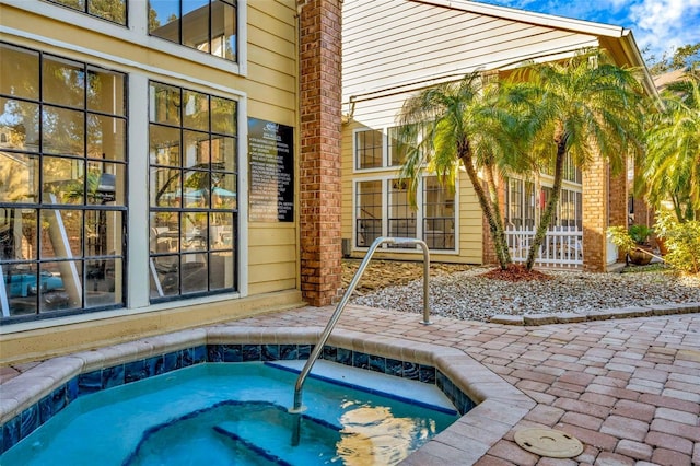 view of swimming pool featuring an in ground hot tub