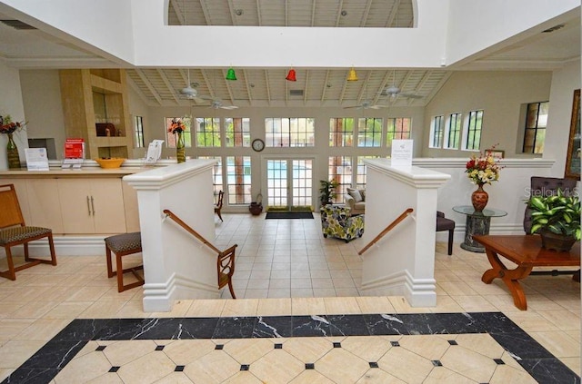tiled foyer with visible vents and a towering ceiling