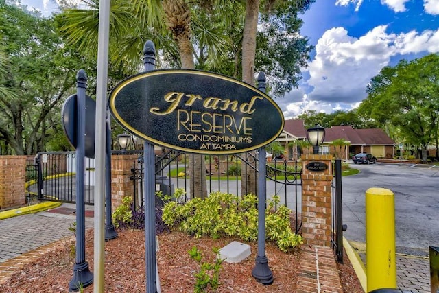 community / neighborhood sign with fence and a gate