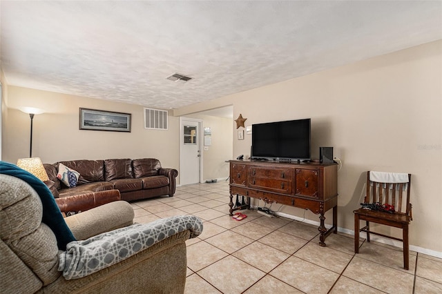 living area featuring visible vents, a textured ceiling, baseboards, and light tile patterned flooring