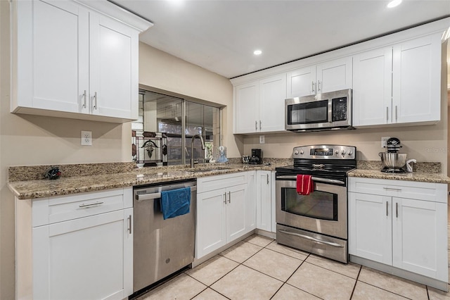 kitchen with light tile patterned floors, recessed lighting, appliances with stainless steel finishes, white cabinets, and a sink