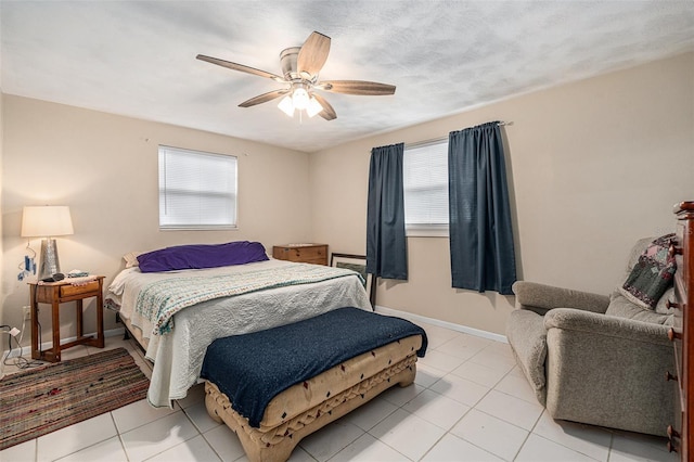 bedroom with ceiling fan, multiple windows, baseboards, and a textured ceiling