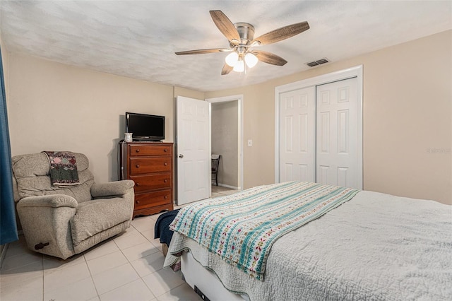 bedroom with light tile patterned floors, ceiling fan, a closet, and visible vents