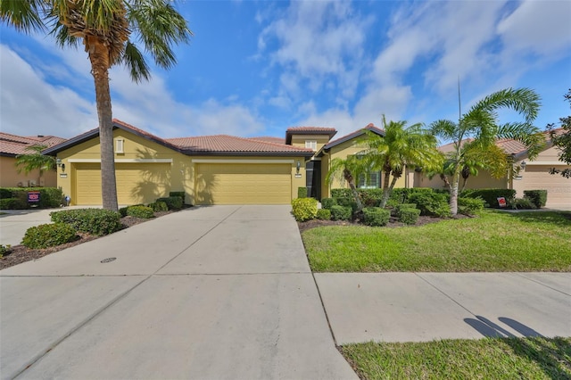 view of front facade featuring a garage, driveway, a tile roof, a front lawn, and stucco siding