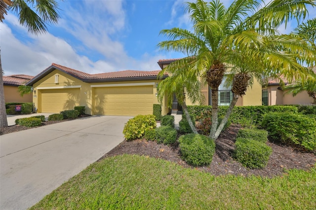 mediterranean / spanish-style house with a garage, a tile roof, driveway, and stucco siding