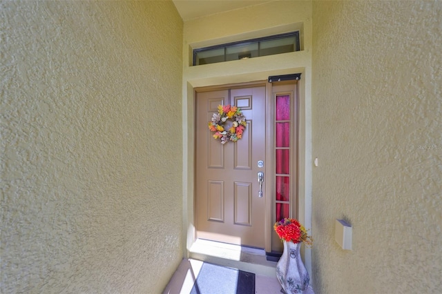 view of exterior entry with stucco siding