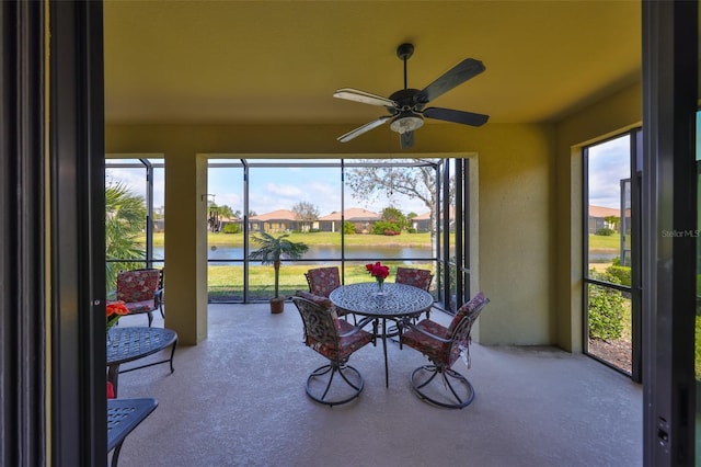 sunroom / solarium featuring a water view, a ceiling fan, and a wealth of natural light