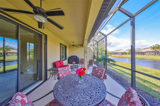 sunroom / solarium with a water view and ceiling fan