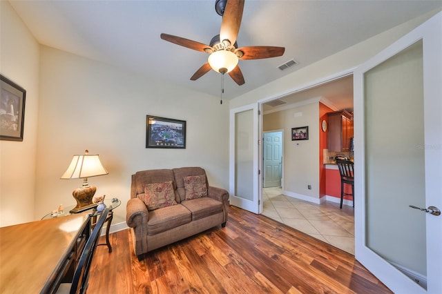 living room featuring baseboards, visible vents, and wood finished floors